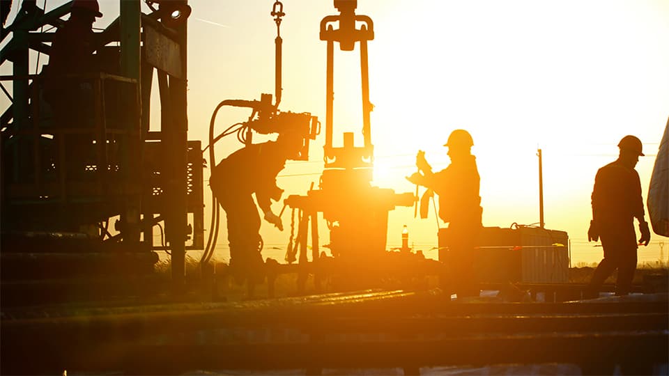 Men in hard hats using drilling equipment