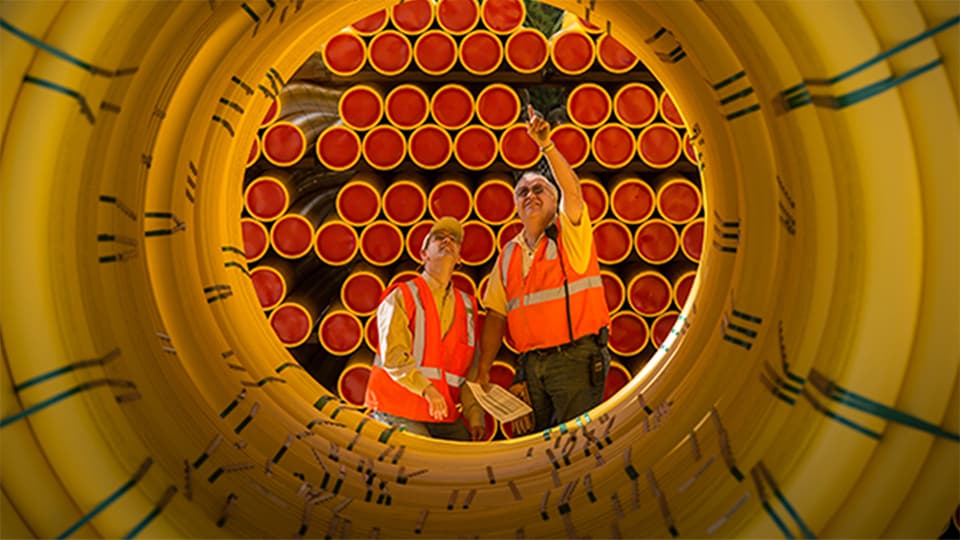 Looking at two men looking at pipe