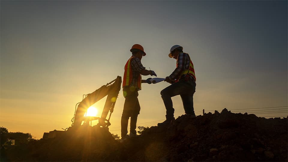 two men discussing plans in a sunset