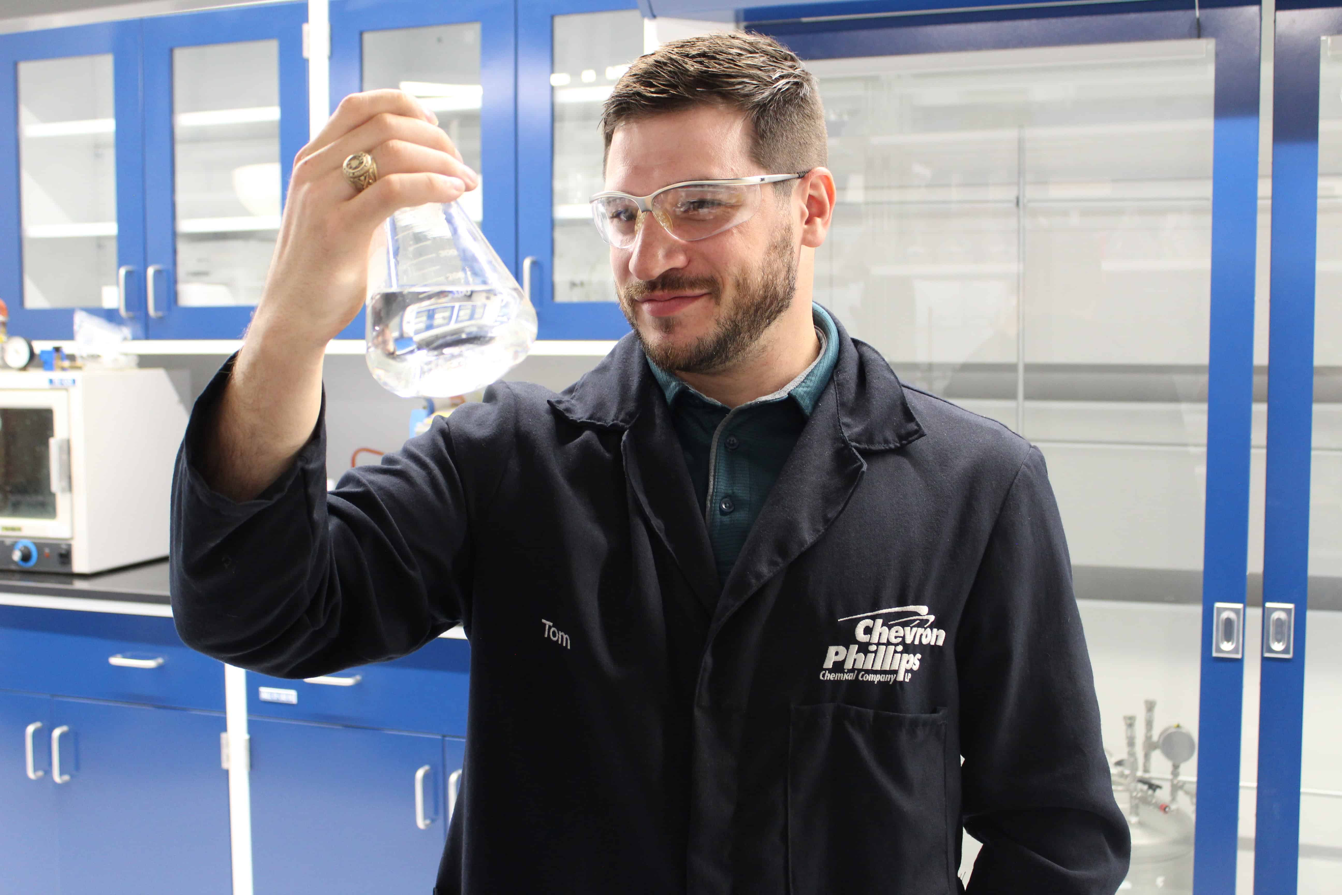 Dr. Tom Holds Beaker in a Lab