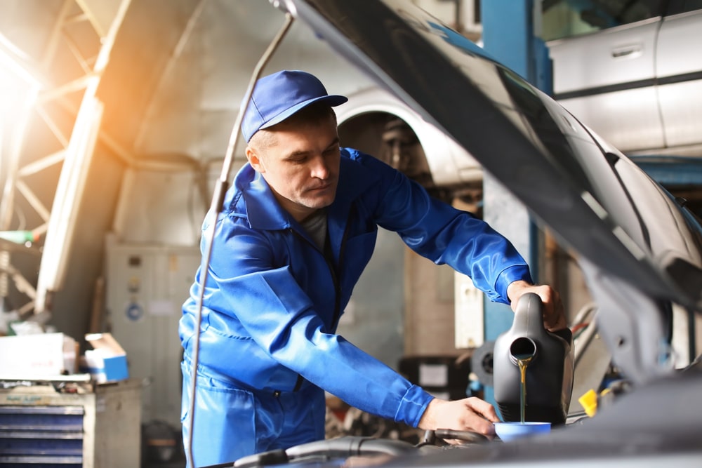 mechanic pouring engine oil