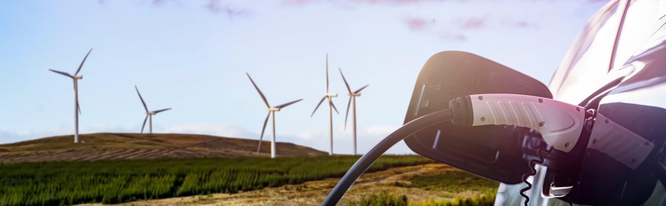 EV Charging with Wind turbines in the background